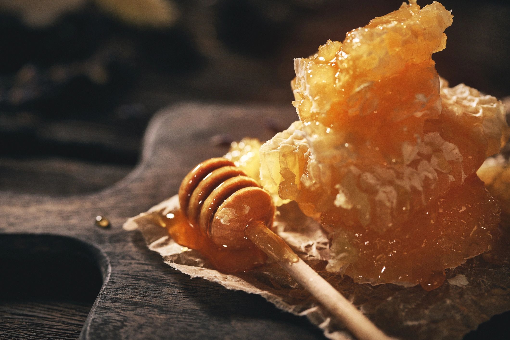 Honeycomb and honey dipper on a wooden table
