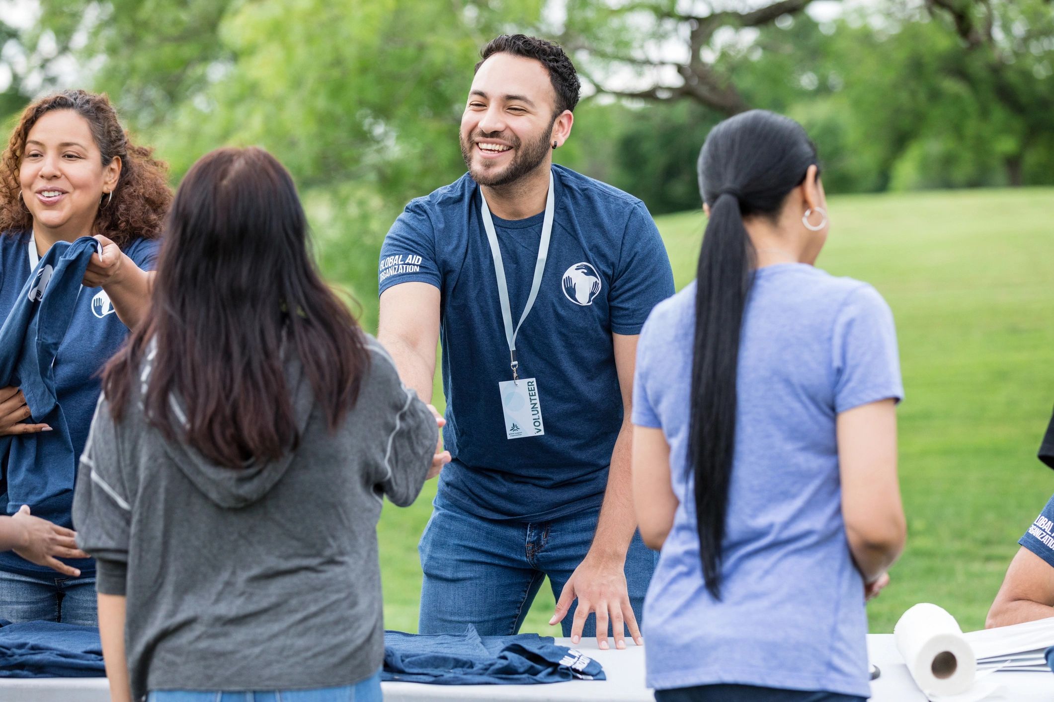 Volunteer greeting someone with a handshake outdoors