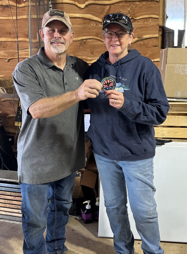 Two men smiling and holding a small trophy indoors.